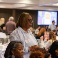people standing and sitting at luncheon table photo 2